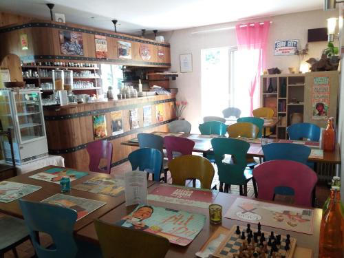 un comedor con mesas y sillas y un tablero de ajedrez en Acacias Hôtel Motel, en Vendays-Montalivet