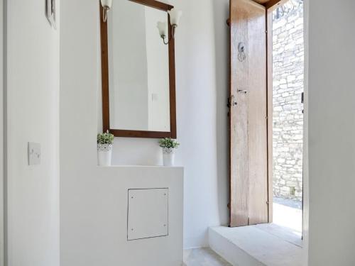 a white bathroom with a mirror and a door at Lefkara View in Pano Lefkara