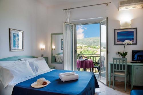 a bedroom with a blue bed and a balcony at Albergo Villa A Mare in Peschici
