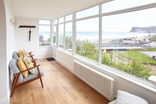 a living room with a large window overlooking the ocean at Burnsyde Beach House - With Sea Views in Saltburn-by-the-Sea