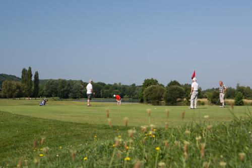 a group of people playing golf in a field at Fasthôtel Périgueux in Marsac-sur-lʼIsle