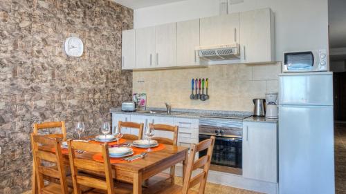 a kitchen with a table and chairs and a refrigerator at Edificio Prieto VIV 2E in Puerto del Rosario