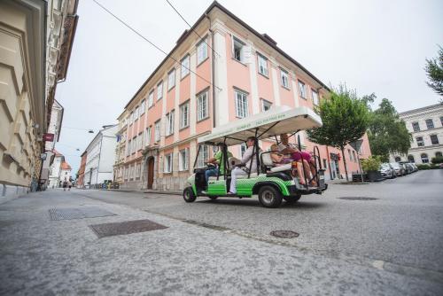 a group of people riding a golf cart down a street at Feel Ljubljana Centre in Ljubljana