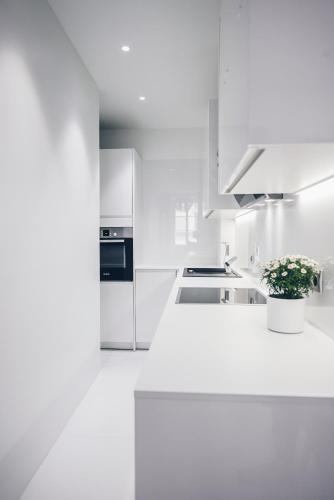 a white kitchen with white counters and appliances at Feel Ljubljana Centre in Ljubljana