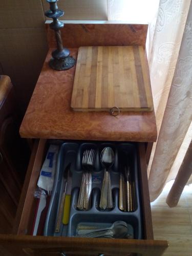 a drawer filled with utensils in a wooden box at Apartment Zhemchuzhina Ureki in Ureki