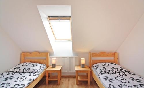 two twin beds in a room with a window at U Slunce in Čížov