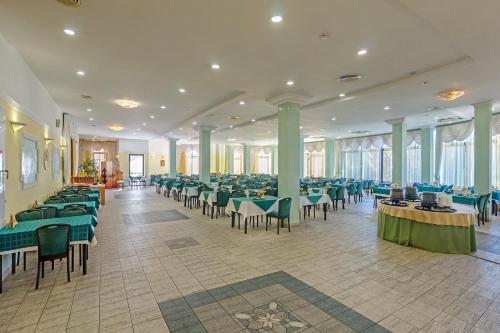 a banquet hall with green tables and chairs at Zeleny Guy Health Resort in Tuapse