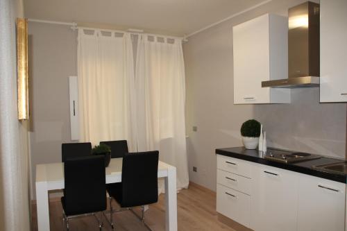 a kitchen with a white table and black chairs at CallaslivinG in Verona