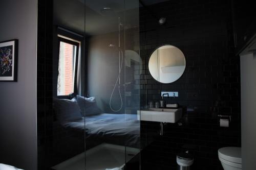 a bathroom with a shower and a sink and a mirror at HotelO Kathedral in Antwerp
