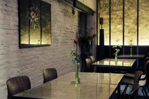 two tables in a restaurant with flowers on them at HotelO Kathedral in Antwerp