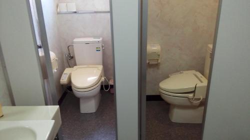 a bathroom with two toilets and a sink at 海辺のゲストハウスーぽかぽか村ー in Ise