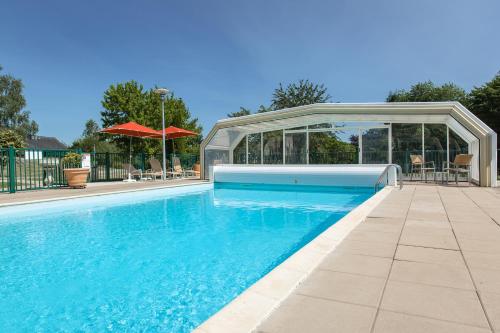 einen Pool mit Pavillon neben einem Pool in der Unterkunft L'Ermitage Hotel & Restaurant in Saulges