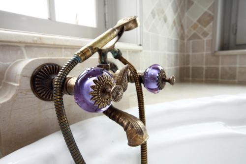 a bath tub with a faucet with aperature at Le Domaine Du Lieu Athan ,réservé aux adultes in Saint-Gâtien-des-Bois