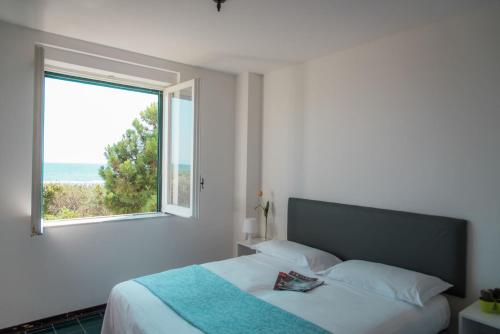 1 dormitorio con 1 cama y ventana grande en Homeholiday Giulivo, en Baia Domizia