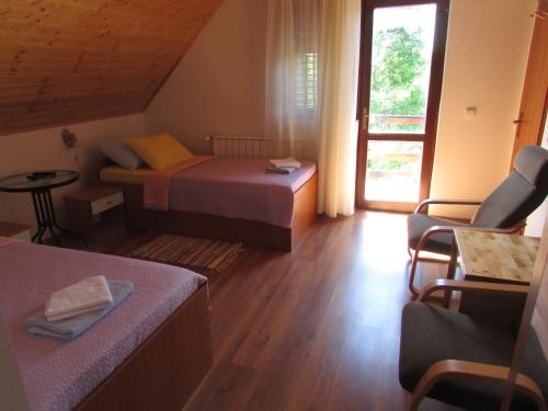 Habitación pequeña con 2 camas y ventana en Guest House Nenad, en Lagos de Plitvice