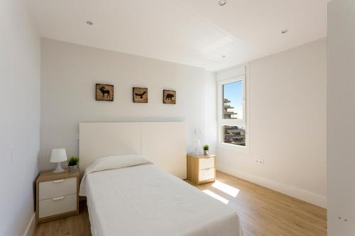 biała sypialnia z łóżkiem i oknem w obiekcie weforyou Two Rooms Terramar Alto with Sea View w mieście Benalmádena