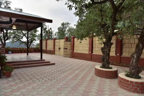 a pavilion with two trees and a fence at The Oaktree House in Shimla
