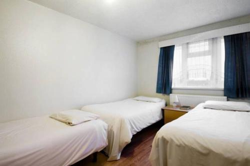 a room with two beds and a window at Wood Green direct tube Eurostar Heathrow, close Ally Pally in London