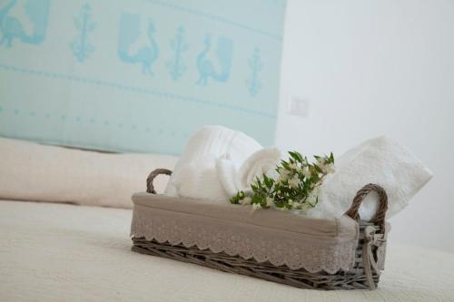 a basket of towels and towels on a bed at Via dei Mari Guest House in Oristano