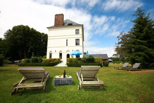 two chairs and a table in front of a building at Le Domaine Du Lieu Athan ,réservé aux adultes in Saint-Gâtien-des-Bois