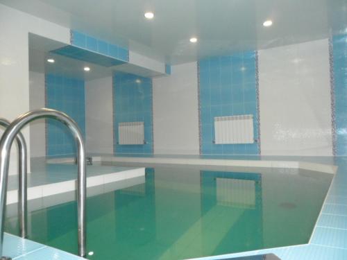 una piscina con paredes azules y blancas y azulejos azules en Gostiniy Dvorik Guest House, en Yaroslavl