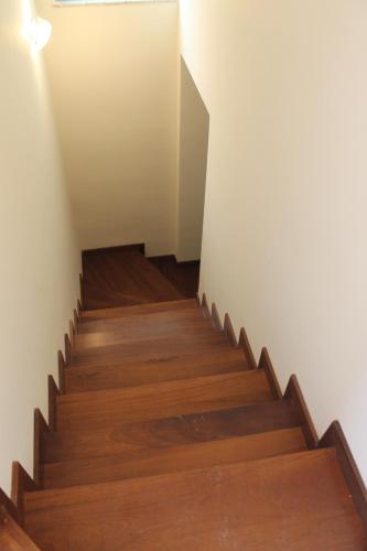a staircase with wooden floors and a white wall at CIAK Affittacamere in Mulazzo