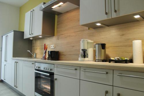 a kitchen with white cabinets and an oven at Palatium Bad Ems in Bad Ems