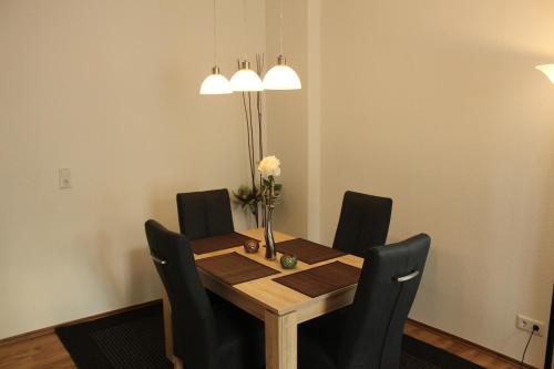 a dining room table with chairs and a vase of flowers at Palatium Bad Ems in Bad Ems