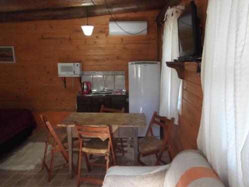 卡内拉Cabanas El Polista的配有桌椅和冰箱的厨房
