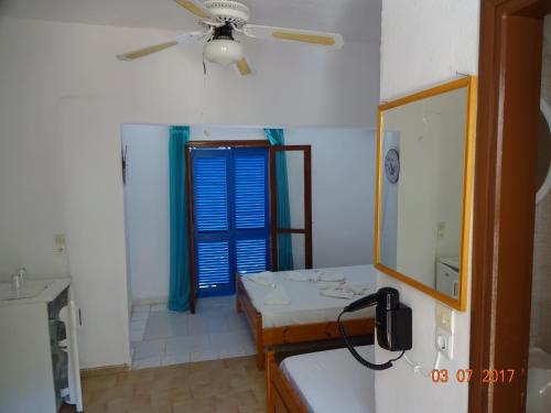 a bathroom with a sink and a ceiling fan at Scirocco Rooms in Loutro