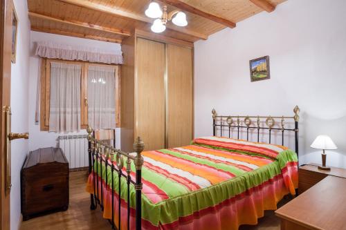 1 dormitorio con 1 cama con una manta colorida en Casa Rural El Fronton, en Vadillo