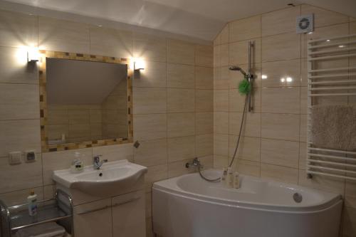 a bathroom with a sink and a tub and a mirror at Dom u Ewy Bory Tucholskie in Śliwice