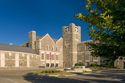 a large brick building with a clock tower on it at The Inn at Virginia Tech - On Campus in Blacksburg
