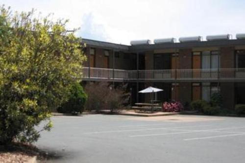 un gran aparcamiento frente a un edificio en Red Cedars Motel, en Canberra