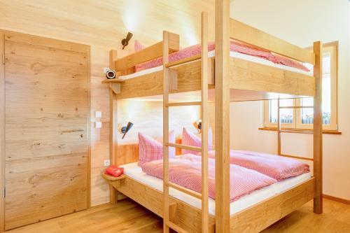 リーツラーンにあるGastler Chaletのベッドルーム1室(ピンクのシーツが備わる二段ベッド2組付)