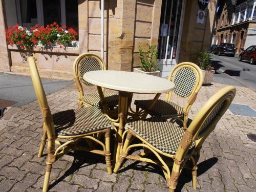 a table and four chairs sitting next to a table and chairs at Hôtel de la Meuse in Charleville-Mézières