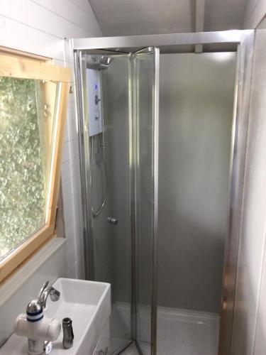 a shower with a glass door in a bathroom at Cherry Tree Gypsy Wagon Sibford Gower in Banbury