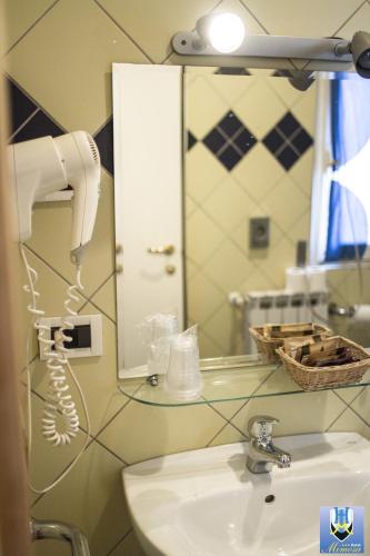 a bathroom with a hair dryer and a sink at Hotel Mimosa in Spotorno