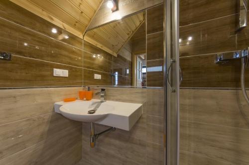 uma casa de banho com um lavatório e um chuveiro em Domki Morskie Tarasy em Jastrzebia Gora