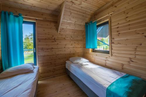 Domki Morskie Tarasy tesisinde bir odada yatak veya yataklar