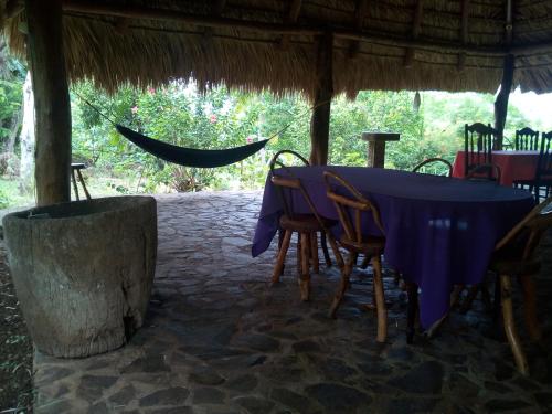 a table and chairs in a tent with a hammock at Eco-Lodge El Porvenir. in Santa Cruz