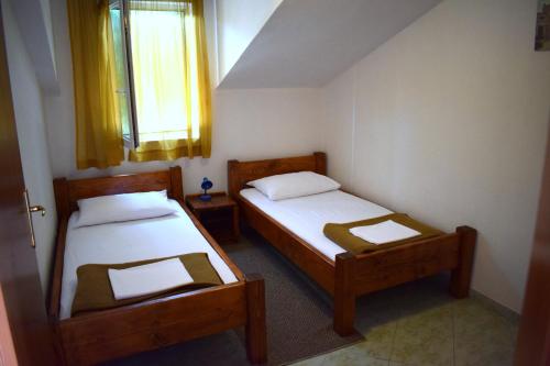 two beds in a small room with a window at Apartments Matulic in Zadar