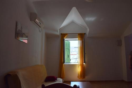 um quarto com uma janela com uma cortina laranja em Apartments Matulic em Zadar