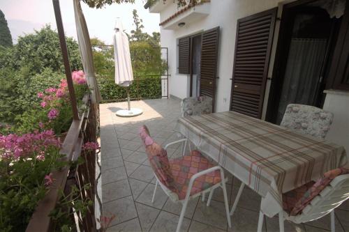 a patio with a table and chairs and a umbrella at Apartments Cvelic Milovcic in Malinska