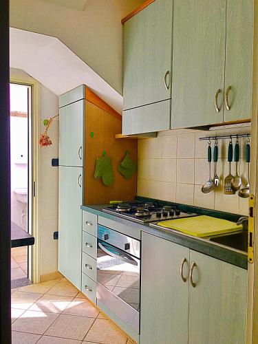 a kitchen with green cabinets and a stove top oven at Casa Anter Santa Maria di Leuca in Leuca
