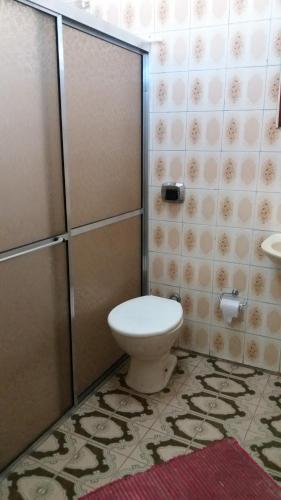 a bathroom with a toilet and a shower stall at Hotel Queluz in Conselheiro Lafaiete