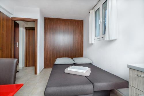 pokój z łóżkiem w rogu pokoju w obiekcie Thea Villas Aegina w mieście Perdika