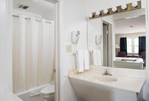 Baño blanco con lavabo y espejo en Travelers Rest Motel en Intercourse