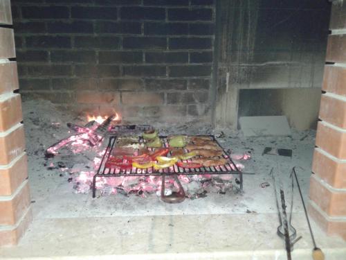 a brick oven with a grill with food on it at Apartment Nevena in Omiš