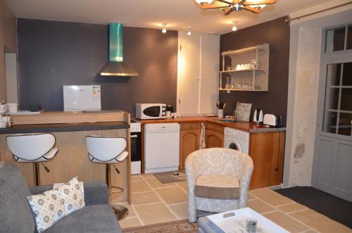 a living room with a kitchen with a couch and chairs at Studio Moncoeur in Le Blanc